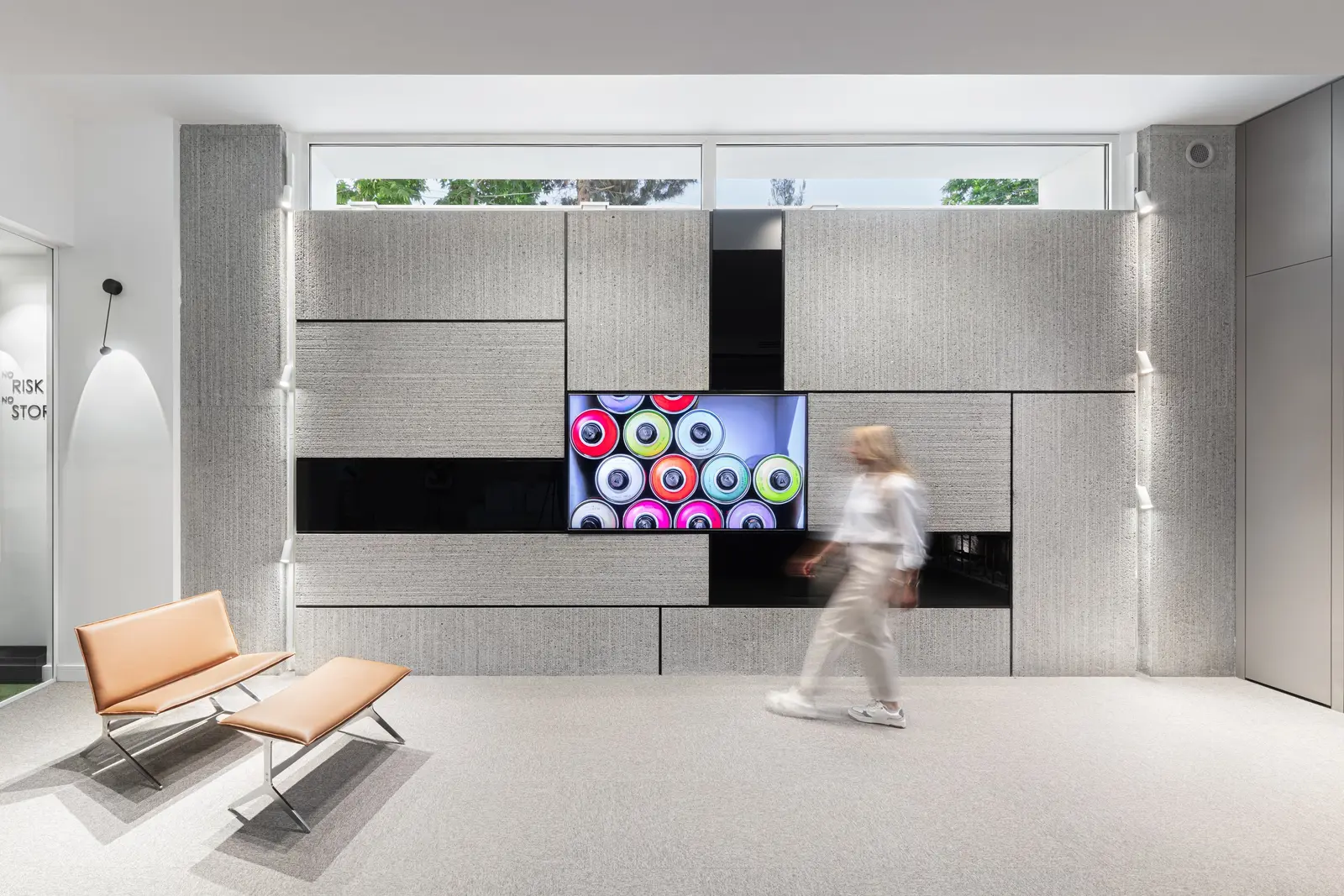 Grey media wall with built-in screen and lounge chairs