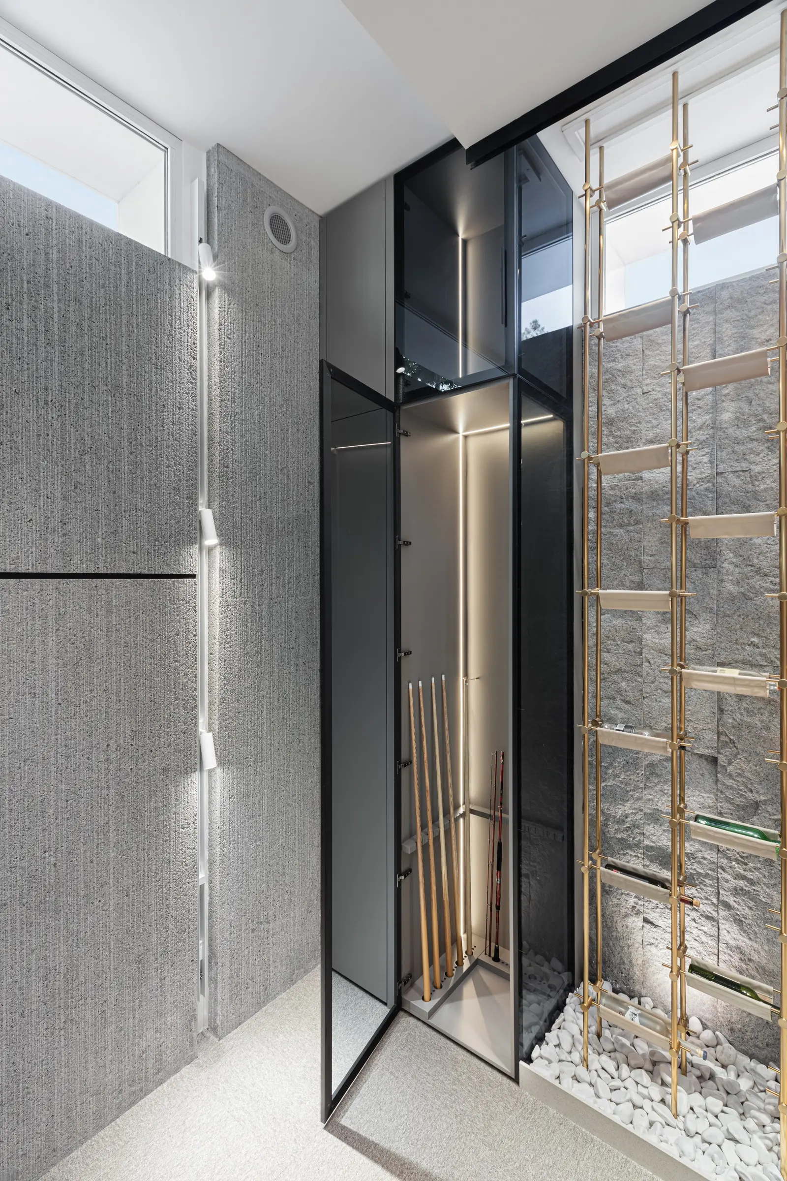 Glass cabinet for fishing rods beside the stone wall