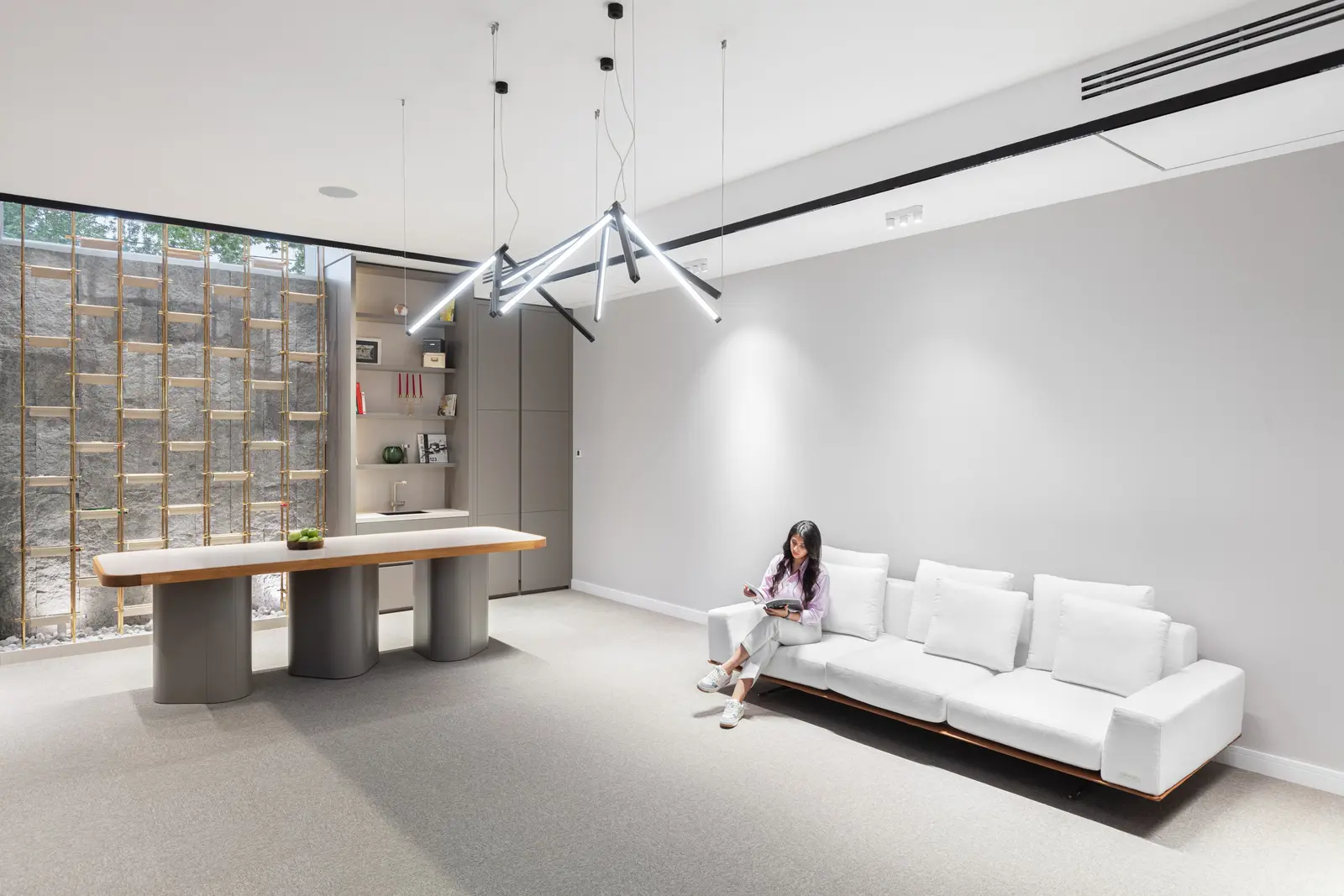 White sofa, long table and linear pendant