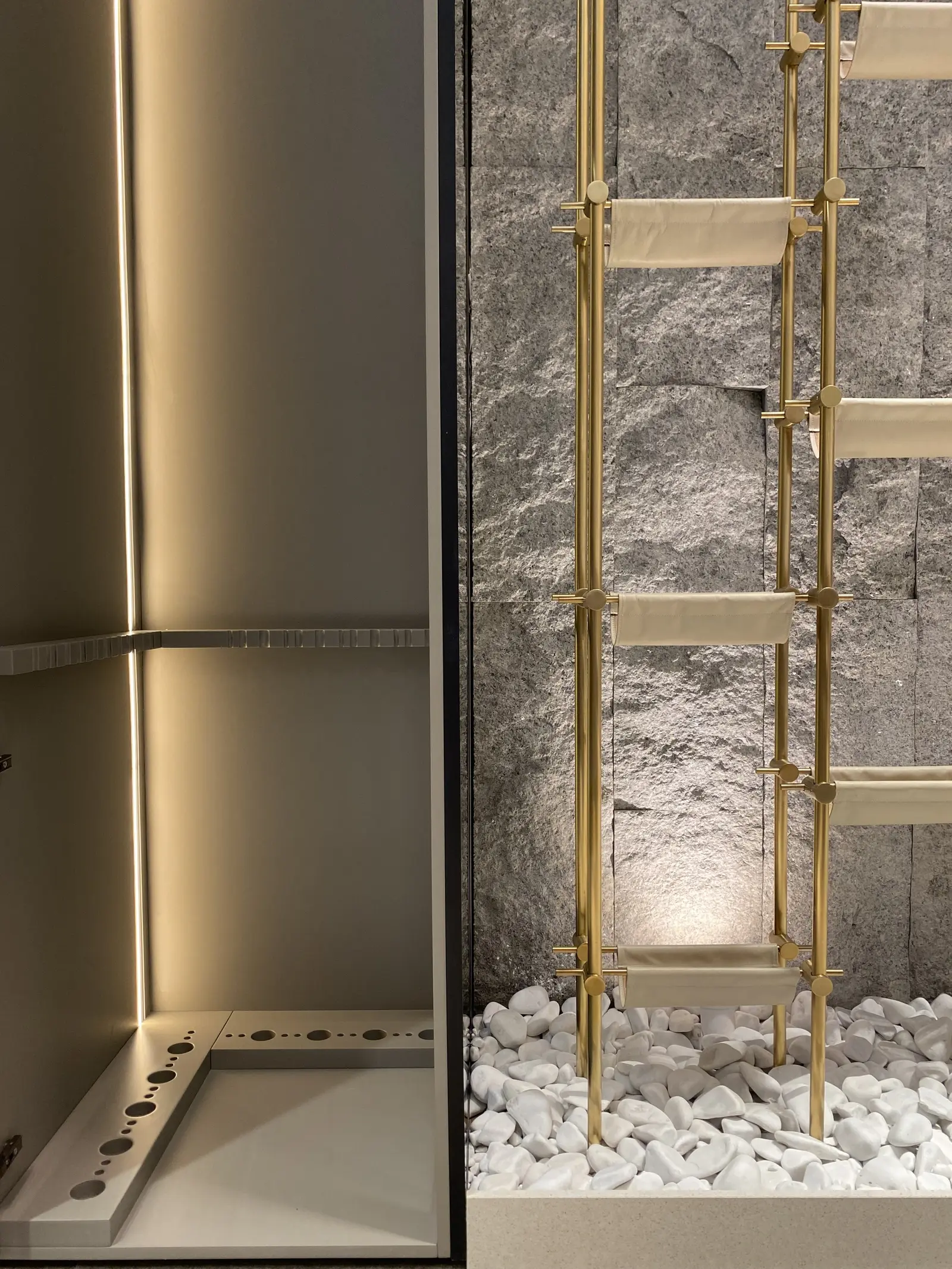 Wine wall: brass rack, stone and linear light